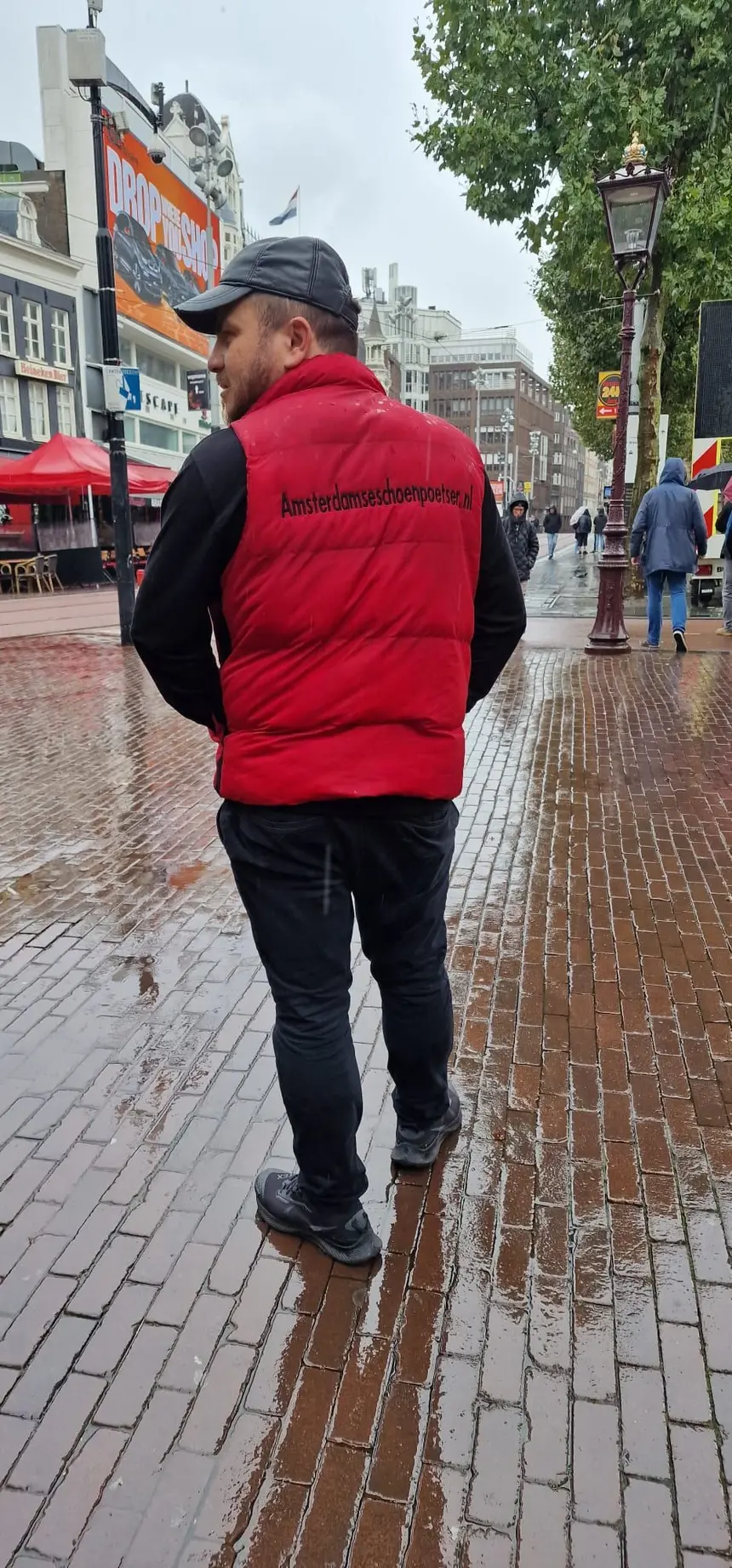 Ali als De Amsterdamse Schoenpoetser op een regenachtige dag in Amsterdam